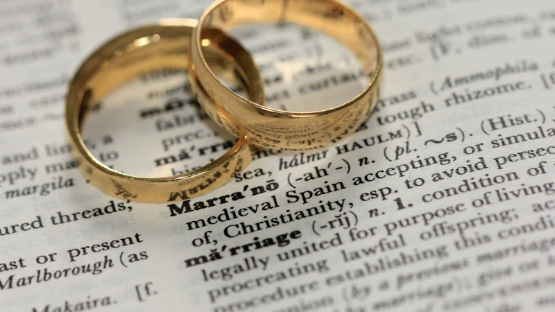 Duas alianças de casamento sobre a página de um dicionário